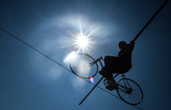 A man on a bicycle offering guests a daring highwire performance on Freedom Square. - Sputnik International