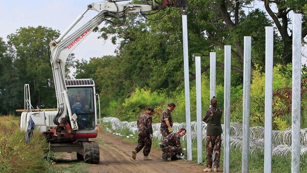 Soldiers build a barbed wire fence at the Hungary-Croatia border near Sarok, Hungary, September 20, 2015. - Sputnik International