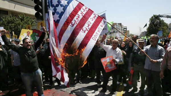 Iranian demonstrators burn a representation of the U.S. flag reading down with America, in Arabic and Persian, during an annual pro-Palestinian rally marking Al-Quds (Jerusalem) Day at the Enqelab-e-Eslami (Islamic Revolution) St. in Tehran, Iran, Friday, July 10, 2015 - Sputnik International
