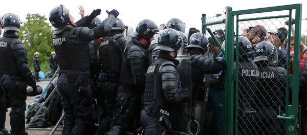 Police try to stop migrants pushing to enter a bus at the Croatia-Slovenia border crossing at Bregana, Croatia, September 20, 2015 - Sputnik International