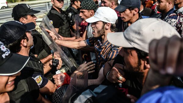 Migrants and refugees try to push a police barricade after they were blocked by Turkish riot police while walking towards Edirne on September 21, 2015 in Istanbul - Sputnik International