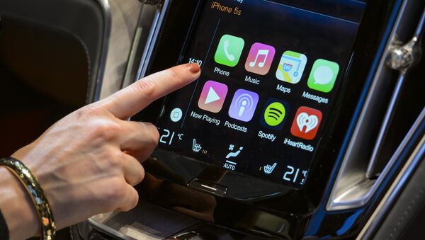 A visitor presses the new Apple's CarPlay touch-screen commands inside the Volvo Estate concept car displayed at the Swedish carmaker during the press day of the Geneva Motor Show in Geneva, on March 4, 2014. - Sputnik International