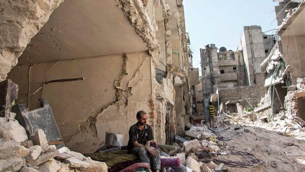 A Syrian man sits in the rubble following a barrel bomb attack the previous day on the rebel-held neighbourhood of al-Mashad in the northern Syrian city of Aleppo on September 17, 2015 - Sputnik International