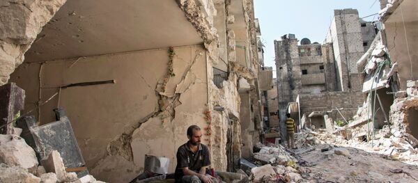 A Syrian man sits in the rubble following a barrel bomb attack the previous day on the rebel-held neighbourhood of al-Mashad in the northern Syrian city of Aleppo on September 17, 2015 A Syrian man sits in the rubble following a barrel bomb attack the previous day on the rebel-held neighbourhood of al-Mashad in the northern Syrian city of Aleppo on September 17, 2015 - Sputnik International