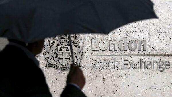 A man shelters under an umbrella as he walks past the London Stock Exchange in London, Britain, in this August 24, 2015 file photo - Sputnik International