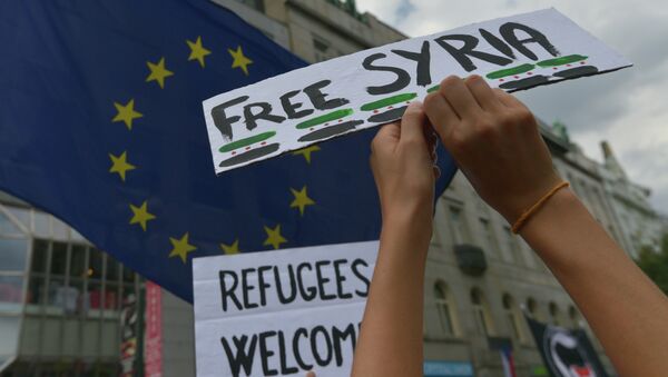 People hold banners with ''Free Syria'' and ''Refugees welcome'' on them during a demonstration supporting the refugees coming to the European Union on July 18 in Prague - Sputnik International