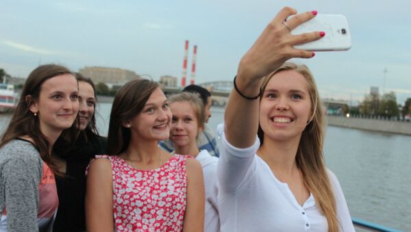 Polish literature and poetry students, arriving over the weekend for a weeklong trip to Russia, seen here posing for photos along the Moscow River. - Sputnik International