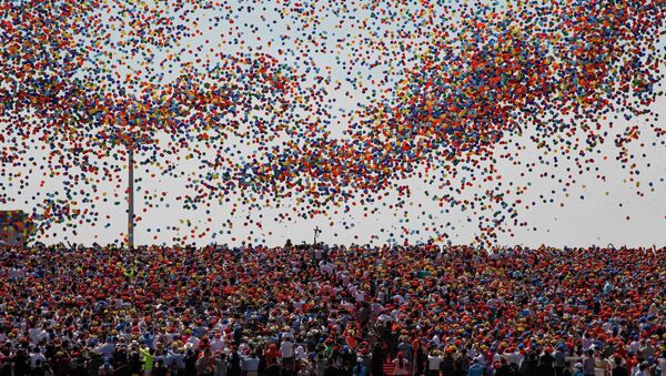 Balloons are released as a crowd looks up during a military parade over Tiananmen Square in Beijing on September 3, 2015, to mark the 70th anniversary of victory over Japan and the end of World War II - Sputnik International