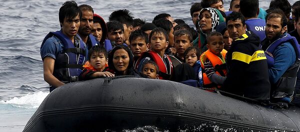 Exhausted Afghan migrants arrive on the Greek island of Lesbos in an overcrowded dinghy after crossing a part of the Aegean Sea from the Turkish coast September 22, 2015 - Sputnik International