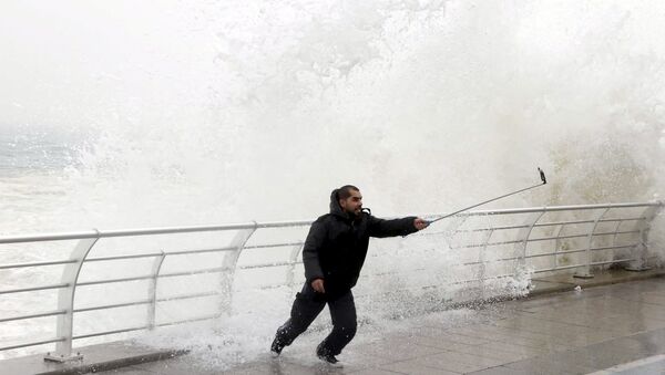 A man takes a selfie by a crashing wave on Beirut's Corniche, a seaside promenade, as high winds sweep through Lebanon during a storm in this February 11, 2015 file photo. - Sputnik International