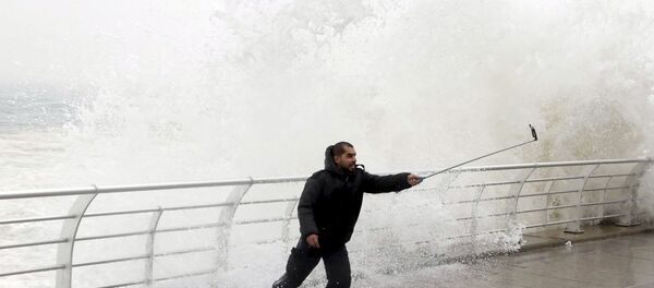 A man takes a selfie by a crashing wave on Beirut's Corniche, a seaside promenade, as high winds sweep through Lebanon during a storm in this February 11, 2015 file photo. - Sputnik International