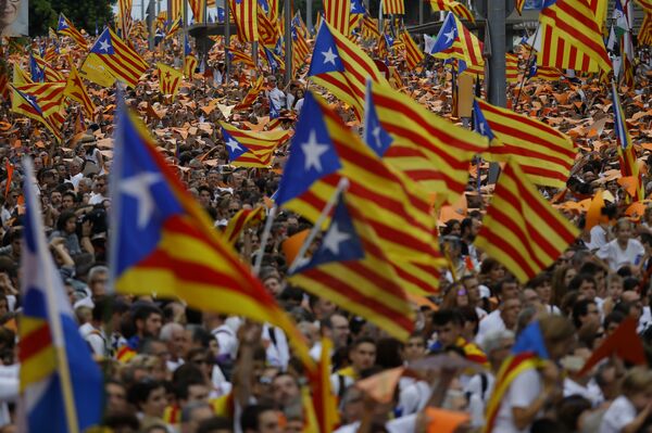 People wave pro-independence Catalan flags, known as the Estelada flag, during a rally calling for the independence of Catalonia, in Barcelona, Spain. - Sputnik International