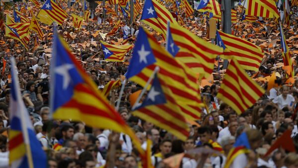 People wave pro-independence Catalan flags, known as the Estelada flag, during a rally calling for the independence of Catalonia, in Barcelona, Spain. - Sputnik International