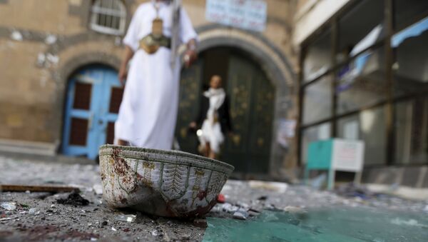People walk past a headgear lying on the ground at the al-Balili mosque after two bombings at the mosque in Yemen's capital Sanaa September 24, 2015 - Sputnik International