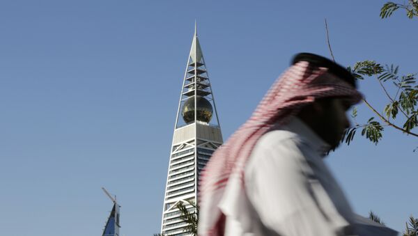 A Saudi man passes the al-Faisaliya tower in Riyadh, Saudi Arabia - Sputnik International