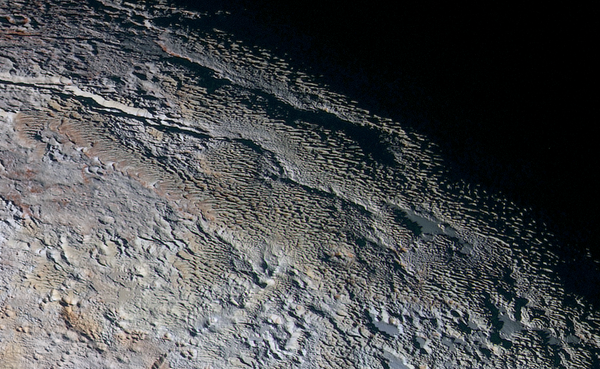 Rounded and bizarrely textured mountains, informally named the Tartarus Dorsa, rise up along Pluto’s day-night terminator and show intricate but puzzling patterns of blue-gray ridges and reddish material in between. Rounded and bizarrely textured mountains, informally named the Tartarus Dorsa, rise up along Pluto’s day-night terminator and show intricate but puzzling patterns of blue-gray ridges and reddish material in between. - Sputnik International