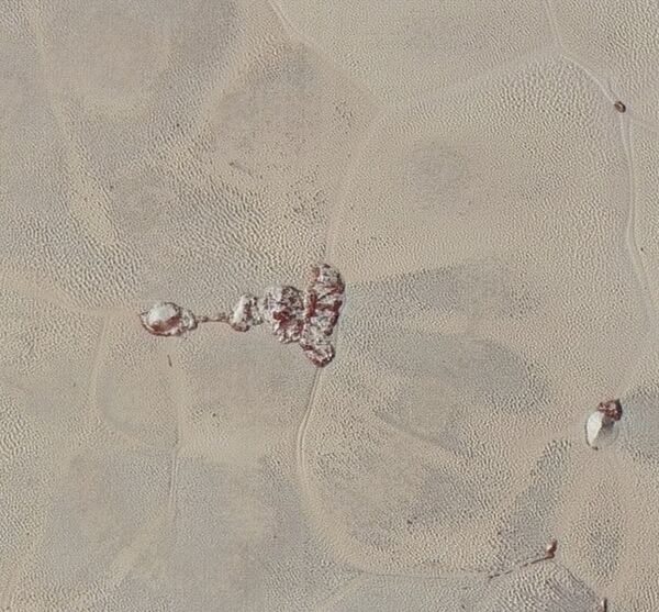 Zooming in on the right section of the above photo shows the textured surface of the plain surrounding two isolated ice mountains. Zooming in on the right section of the above photo shows the textured surface of the plain surrounding two isolated ice mountains. - Sputnik International