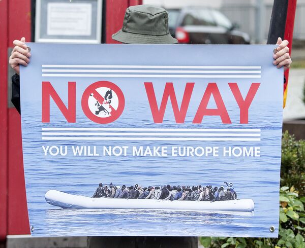 A man holds a banner during a demonstration initiated by right-wing NPD (National Democratic Party of Germany) against the German asylum law and asylum seekers in Riesa, eastern Germany, Tuesday, Aug. 18, 2015. - Sputnik International