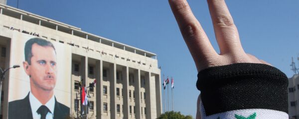 A pro-Syrian regime protester flashes V-victory sign A pro-Syrian regime protester flashes V-victory sign - Sputnik International