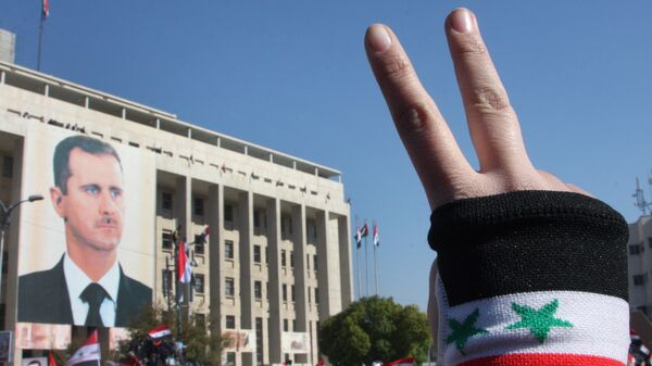 A pro-Syrian regime protester flashes V-victory sign - Sputnik International