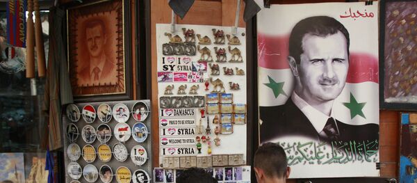 Syrian students, look for souvenir items at a shop displaying a portrait of Syrian President Bashar Assad with Arabic legend reads We love you, in the old city of Damascus, Syria Syrian students, look for souvenir items at a shop displaying a portrait of Syrian President Bashar Assad with Arabic legend reads We love you, in the old city of Damascus, Syria - Sputnik International
