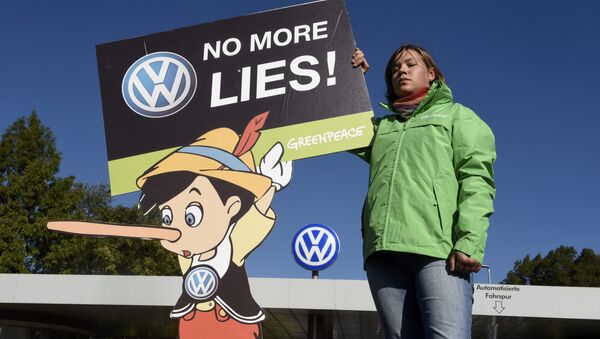 A Greenpeace activist holds a banner during a protest in front of Volkswagen's Sandkamp gate in Wolfsburg, Germany September 25, 2015. - Sputnik International