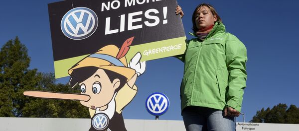 A Greenpeace activist holds a banner during a protest in front of Volkswagen's Sandkamp gate in Wolfsburg, Germany September 25, 2015. A Greenpeace activist holds a banner during a protest in front of Volkswagen's Sandkamp gate in Wolfsburg, Germany September 25, 2015. - Sputnik International
