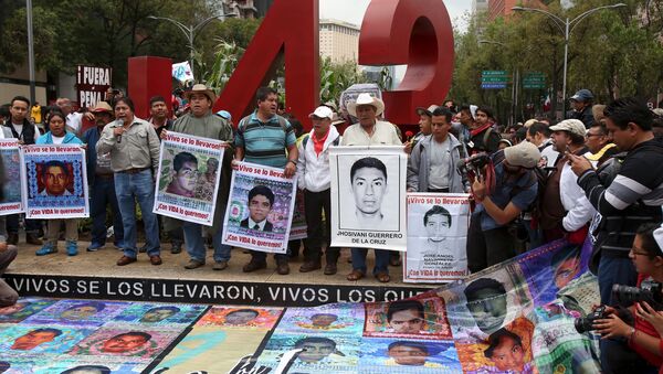 Relatives hold pictures of some of the 43 missing students of Ayotzinapa College Raul Isidro Burgos during a march to mark the first anniversary of their disappearance, in Mexico City, September 26, 2015 - Sputnik International