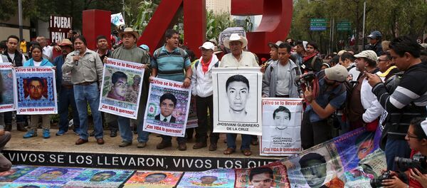 Relatives hold pictures of some of the 43 missing students of Ayotzinapa College Raul Isidro Burgos during a march to mark the first anniversary of their disappearance, in Mexico City, September 26, 2015 Relatives hold pictures of some of the 43 missing students of Ayotzinapa College Raul Isidro Burgos during a march to mark the first anniversary of their disappearance, in Mexico City, September 26, 2015 - Sputnik International
