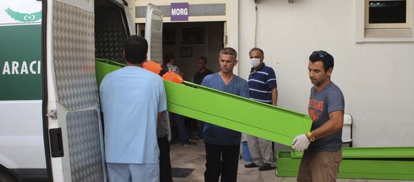 People upload coffins with the bodies of migrants that were drowned while they were trying to cross on a boat to the nearby Greek island of Kos, to the hospital's morgue at the coastal town of Bodrum, Turkey, Sunday, Sept. 27, 2015. Turkey's coast guard says that 17 migrants have drowned after a vessel carrying them toward Greece sank in the Aegean Sea - Sputnik International
