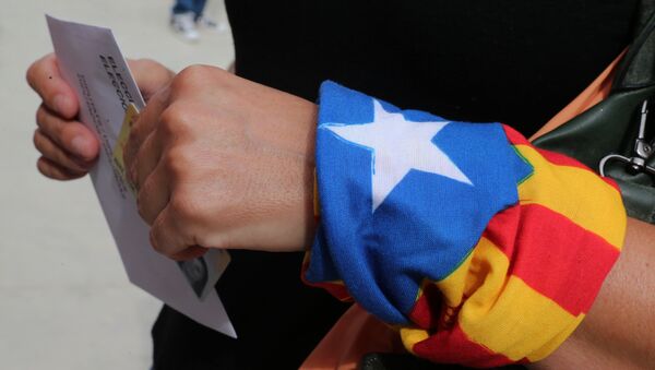 A woman with an Estelada (Catalan pro-independece flag) tied to her wrist waits for casting her ballot for the regional election at a polling station in Badalona on September 27, 2015 - Sputnik International