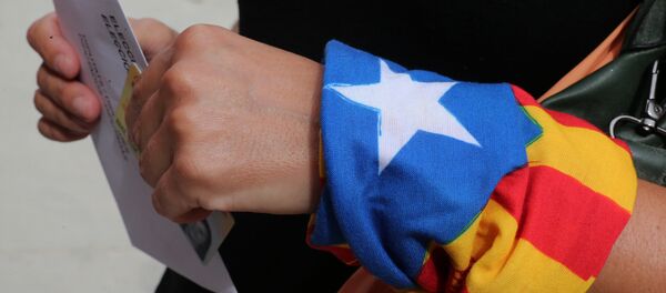 A woman with an Estelada (Catalan pro-independece flag) tied to her wrist waits for casting her ballot for the regional election at a polling station in Badalona on September 27, 2015 A woman with an Estelada (Catalan pro-independece flag) tied to her wrist waits for casting her ballot for the regional election at a polling station in Badalona on September 27, 2015 - Sputnik International
