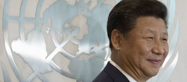 Chinese President Xi Jinping stands in front of the United Nations emblem as he poses for a photograph with U.N. Secretary-General Ban Ki-moon (unseen) after addressing the United Nations Sustainable Development Summit 2015 at the United Nations headquarters in Manhattan, New York September 26, 2015 - Sputnik International