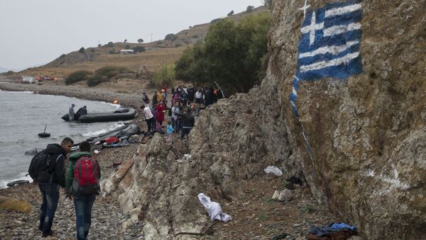 A file photo showing a greek flag is painted on a rock, as migrants arrive on the shores of the Greek island of Lesbos after crossing the Aegean Sea from Turkey on a inflatable dinghy , clamber over rocks on Tuesday, Sept. 22, 2015 - Sputnik International