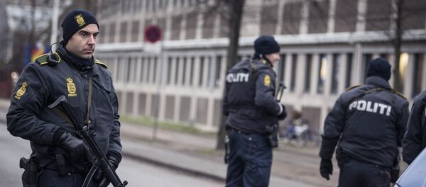 Police officers guard the street around the Noerrebro train station in Copenhagen on February 15, 2015 after a man has been shot in a police action following two fatal attacks in the Danish capital. - Sputnik International