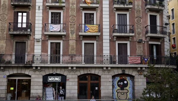 People rest in front of a building on which Estelada flags, a symbol of Catalonian pro-independence, are seen in Barcelona, Spain, September 26, 2015 - Sputnik International