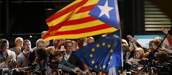 A estelada or pro independence flag and a European Union flag are waved in front of the President of Democratic Convergence of Catalonia Artur Mas, center in front of supporters in Barcelona, Spain, Sunday Sept. 27, 2015 A estelada or pro independence flag and a European Union flag are waved in front of the President of Democratic Convergence of Catalonia Artur Mas, center in front of supporters in Barcelona, Spain, Sunday Sept. 27, 2015 - Sputnik International