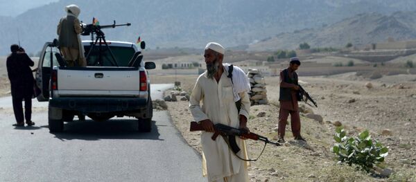 Afghan Local Police (ALP) keep watch along the road near a checkpoint, set alight by Islamic (IS) fighters during overnight clashes between Afghan forces and Islamic state (IS) groups, in Achin district of eastern Nangarhar province on September 28, 2015 - Sputnik International