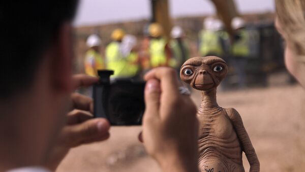 In this April 26, 2014 file photo, a man takes a photo of an E.T. doll in Alamogordo, N.M. Producers of a documentary dug in an southeastern New Mexico landfill in search of millions of cartridges of the Atari 'E.T. the Extra-Terrestrial' game that has been called the worst game in the history of video gaming and were buried there in 1983. - Sputnik International