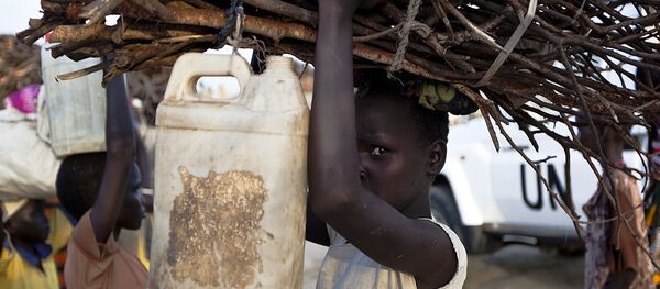 A young woman carries firewood after returning to the United Nations base outside Bentiu, at the end of the day, on September 20, 2015 A young woman carries firewood after returning to the United Nations base outside Bentiu, at the end of the day, on September 20, 2015 - Sputnik International