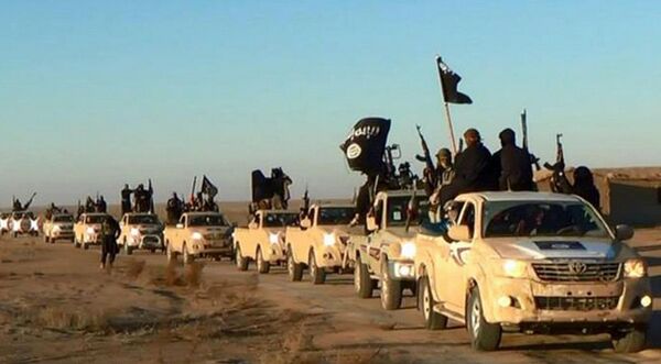 In this undated file photo released by a militant website, which has been verified and is consistent with other AP reporting, militants of the Islamic State group hold up their weapons and wave its flags on their vehicles in a convoy on a road leading to Iraq, while riding in Raqqa city in Syria In this undated file photo released by a militant website, which has been verified and is consistent with other AP reporting, militants of the Islamic State group hold up their weapons and wave its flags on their vehicles in a convoy on a road leading to Iraq, while riding in Raqqa city in Syria - Sputnik International
