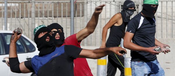 Palestinians hurl stones towards Israeli border police during clashes at a checkpoint between Shuafat refugee camp and Jerusalem September 18, 2015 - Sputnik International