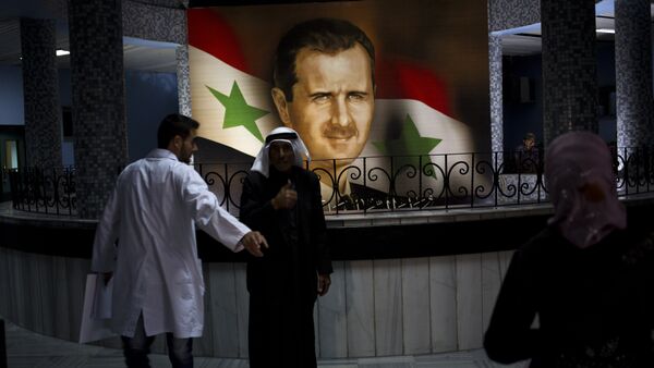 People walk through the Damascus General Hospital past a portrait of the President Bashar Assad in Damascus, Syria, Sunday, May 4, 2014 - Sputnik International