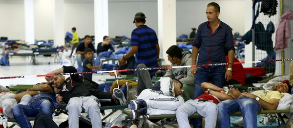 Migrants rest on camp beds at a temporary shelter in Freilassing, Germany September 17, 2015 Migrants rest on camp beds at a temporary shelter in Freilassing, Germany September 17, 2015 - Sputnik International