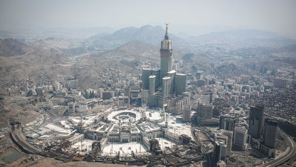 In this aerial photo made from a helicopter, the Abraj Al-Bait Towers with the four-faced clocks stands over the holy Kaaba, as Muslims encircle it inside the Grand Mosque, during the annual pilgrimage known as the hajj, in the Muslim holy city of Mecca, Saudi Arabia, Friday, Sept. 25, 2015. - Sputnik International