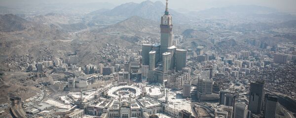 In this aerial photo made from a helicopter, the Abraj Al-Bait Towers with the four-faced clocks stands over the holy Kaaba, as Muslims encircle it inside the Grand Mosque, during the annual pilgrimage known as the hajj, in the Muslim holy city of Mecca, Saudi Arabia, Friday, Sept. 25, 2015. In this aerial photo made from a helicopter, the Abraj Al-Bait Towers with the four-faced clocks stands over the holy Kaaba, as Muslims encircle it inside the Grand Mosque, during the annual pilgrimage known as the hajj, in the Muslim holy city of Mecca, Saudi Arabia, Friday, Sept. 25, 2015. - Sputnik International