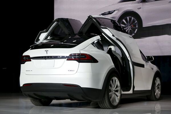 A Tesla Motors Model X electric sports-utility vehicle opens its falcon wing doors on stage during a presentation in Fremont, California September 29, 2015 - Sputnik International