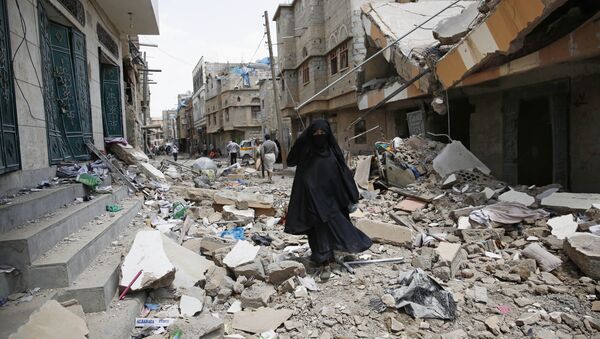 A woman walks amid the rubble of houses destroyed by a Saudi-led airstrike in Sanaa, Yemen, Monday, Sept. 21, 2015 - Sputnik International