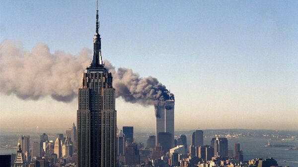 In this file photo, the twin towers of the World Trade Center burn behind the Empire State Building in New York. - Sputnik International