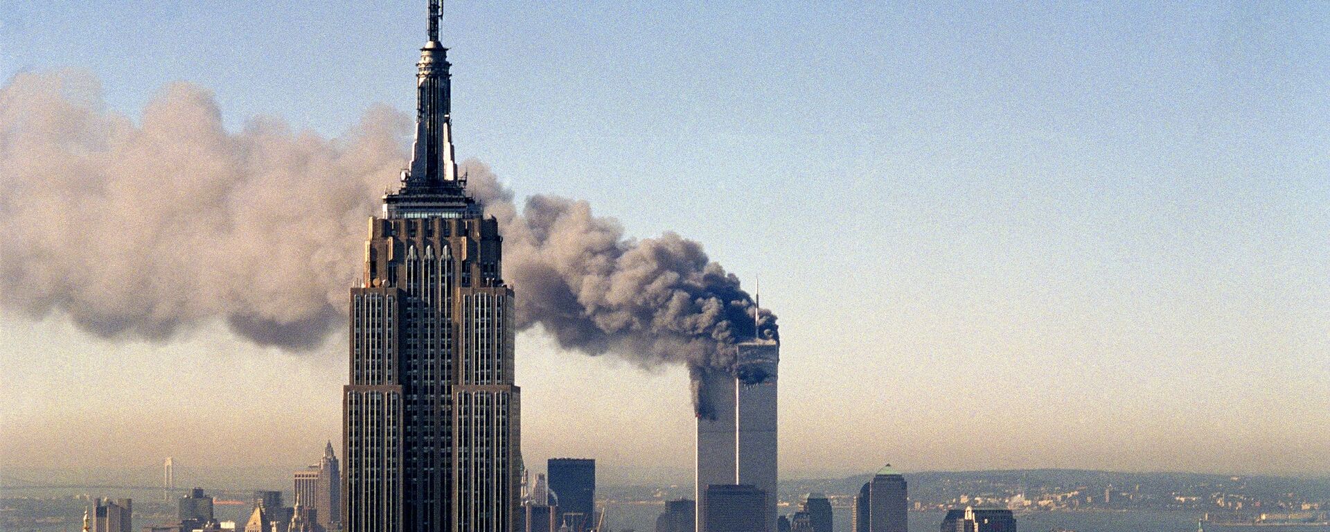 In this Sept. 11, 2001, file photo, the twin towers of the World Trade Center burn behind the Empire State Building in New York. - Sputnik International, 1920, 10.09.2021